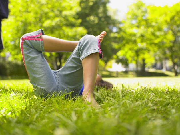 Lower section of girl laying in grass
