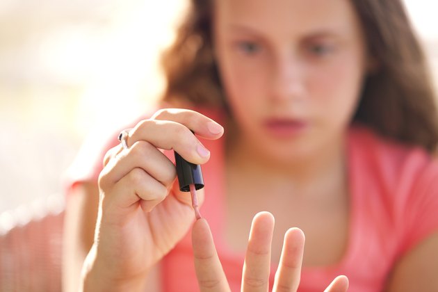 Teenage girl painting fingernails