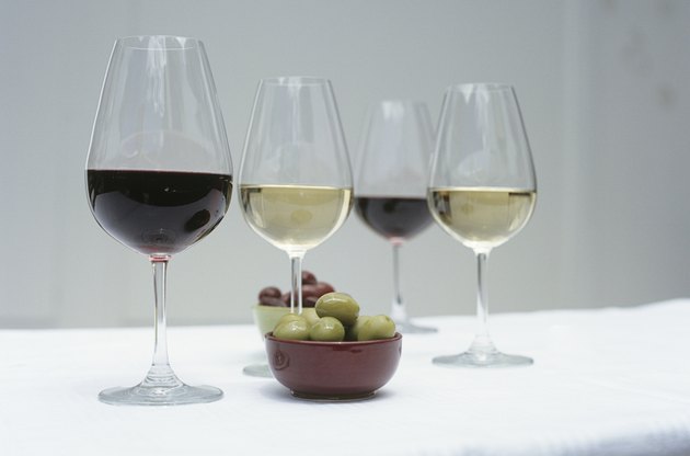 Glasses of wine and olives on table