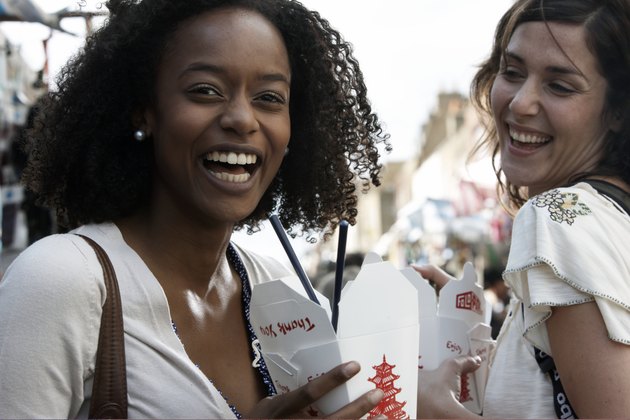 friends laughing with take away noodles