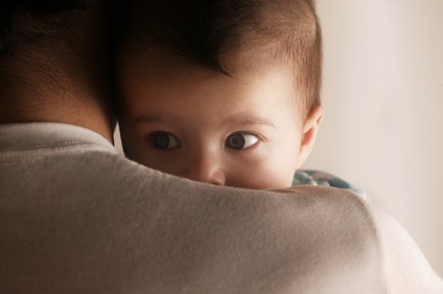 Baby peering over dads shoulder