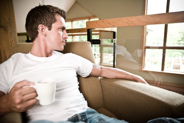 Man relaxing at home with cup of coffee