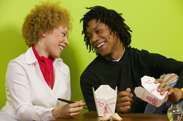 African couple eating takeout food