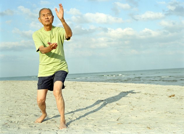 Senior man practicing tai chi on beach