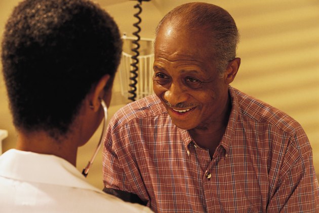 Mature man getting blood pressure checked by nurse or doctor