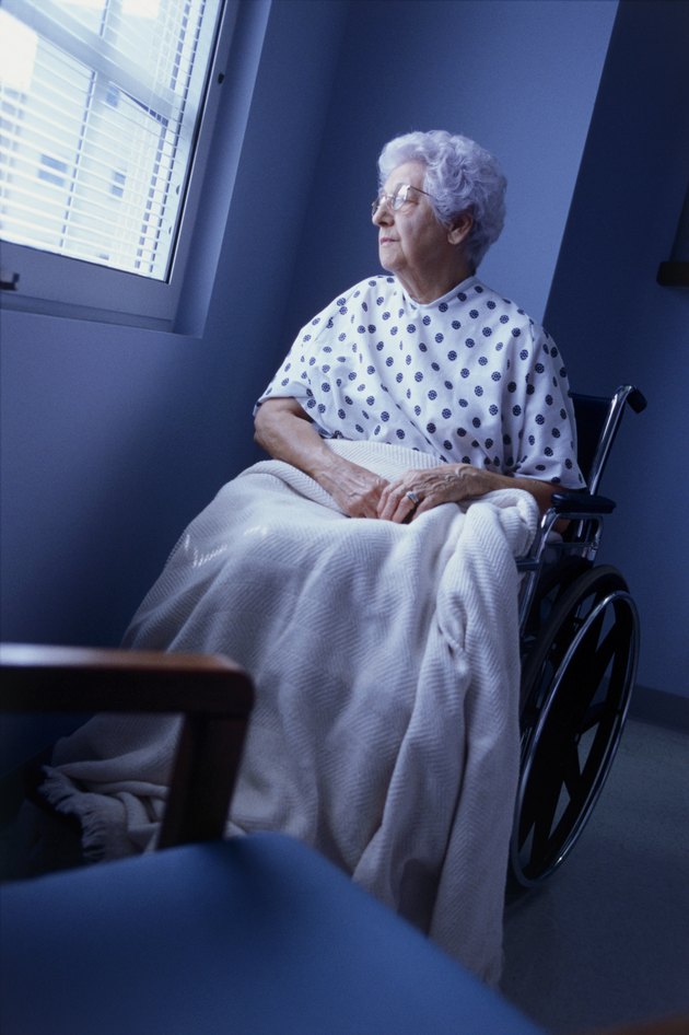 Female patient sitting in a wheelchair looking out of a window