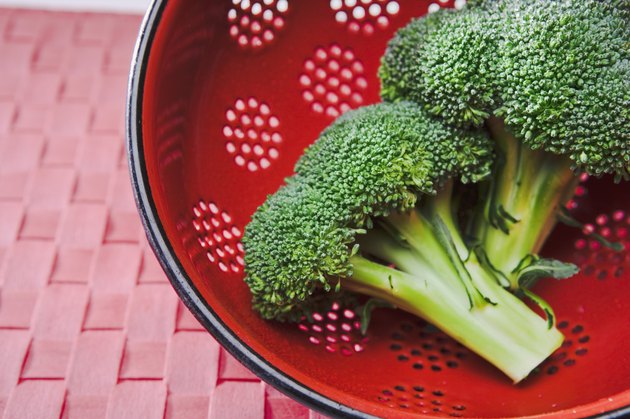 Broccoli crowns in red colander