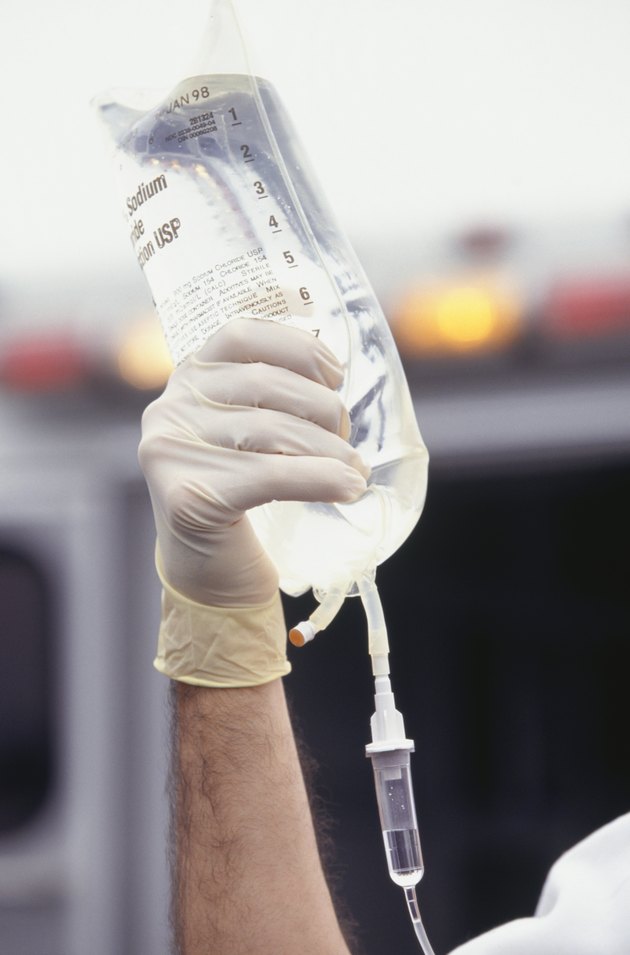 Paramedic holding intravenous bag, close-up of hand