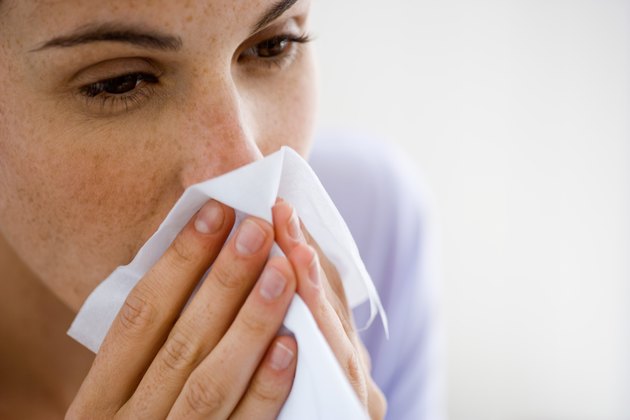 Woman blowing nose