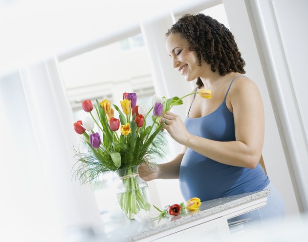 Pregnant African woman arranging flowers