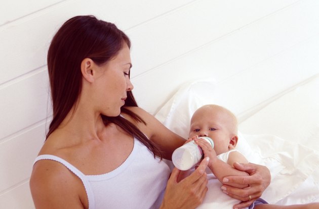 Woman feeding hungry baby with bottle
