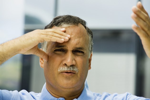 Portrait of a mature man with his hand on his forehead