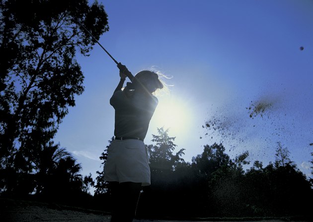 low angle view of a female golfer swinging her golf club