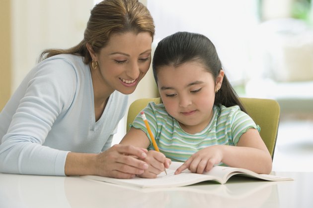 Hispanic mother helping daughter with homework