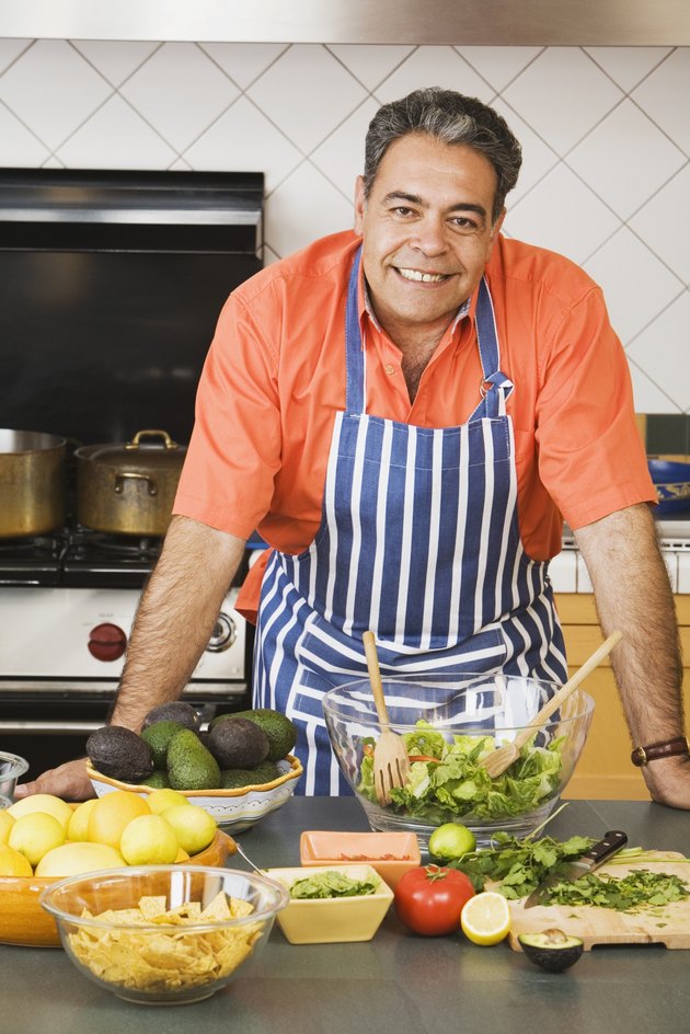 Middle-aged Hispanic man next to food in kitchen