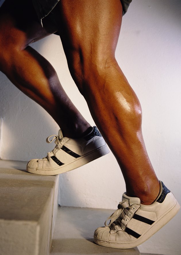 Side profile close-up of the legs of a young man going up a stairs