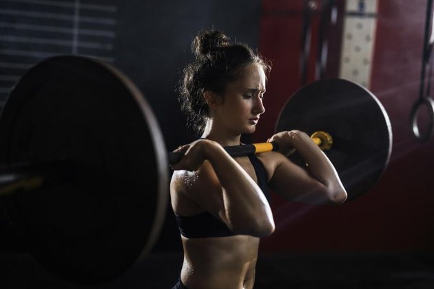 Strong woman holding heavy weight on her shoulders