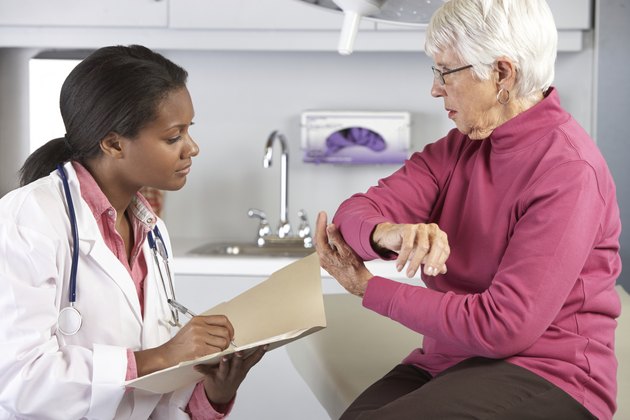 Doctor Examining Female Patient With Elbow Pain