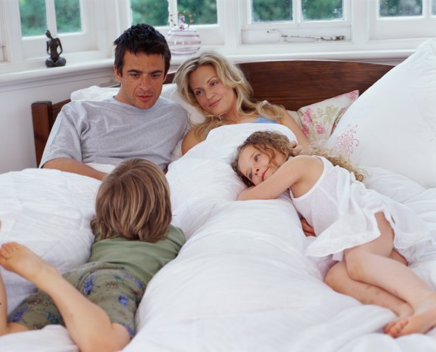 Parents lying in bed with son and daughter (4-6)