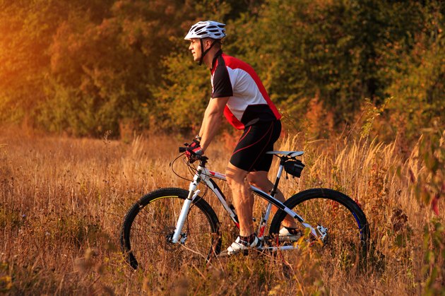 cyclist man cycling on a rural road during sunset