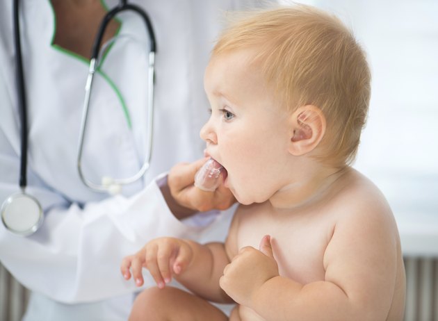 doctor cleans baby teeth
