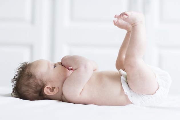 Funny baby girl relaxing with her legs and feet