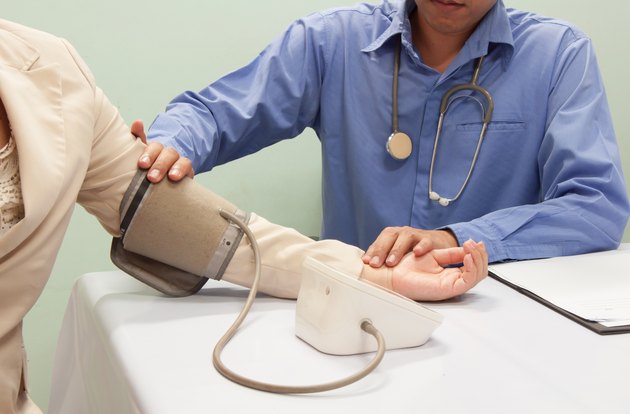 Doctor checking blood pressure of patient