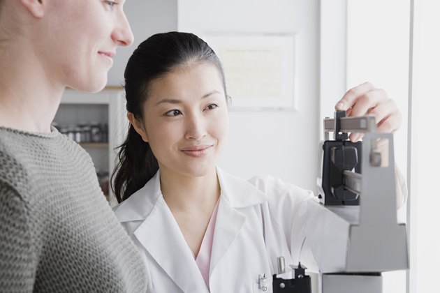 USA, California, Los Angeles, Close up of female doctor measuring woman's weight