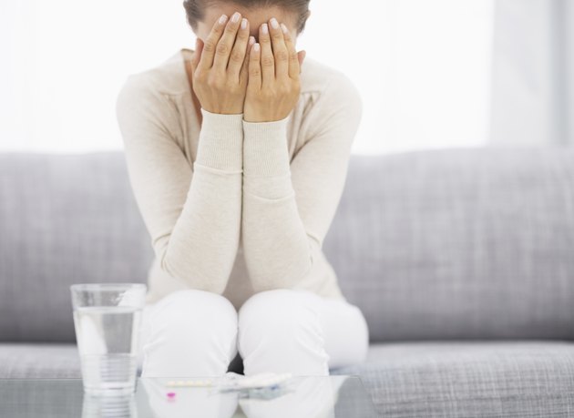 Stressed young woman in room and medicine on table. Closeup