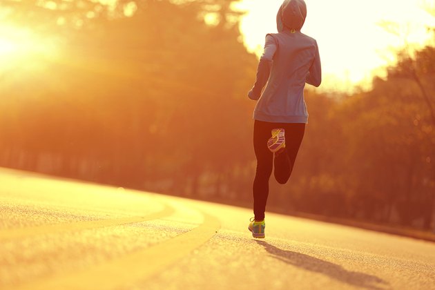 young fitness woman runner athlete running at sunrise road
