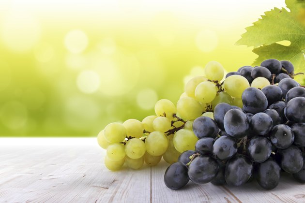 White and red grapes on table in vineyard