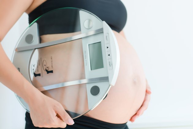 weight gain during pregnancy with pregnant woman holding scale