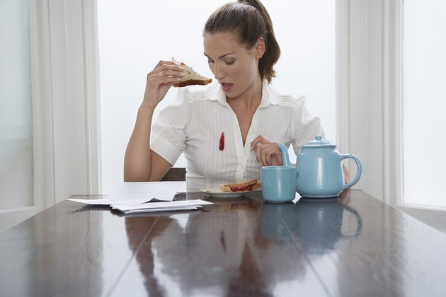 Woman dropping jam down her blouse at breakfast