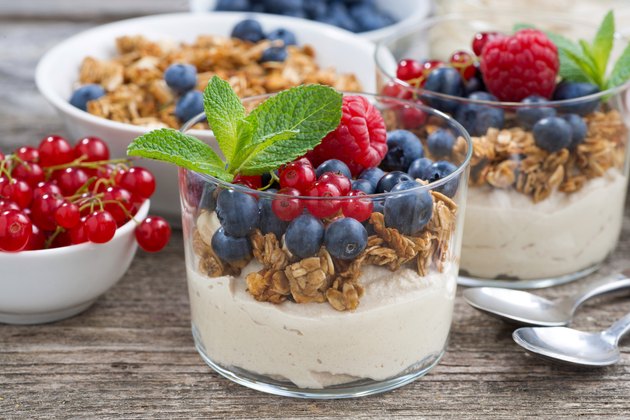 dessert with sweet cream, fresh berries and granola, closeup