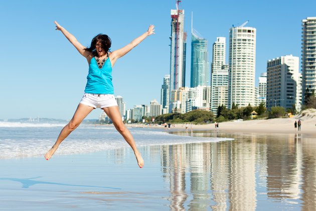 atractive woman jumps with joy on the beach