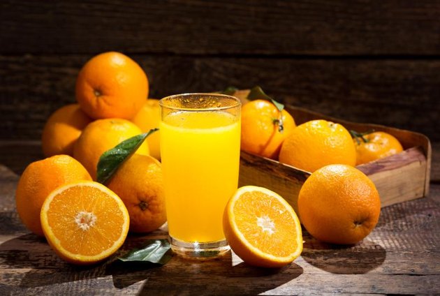 glass of orange juice with fresh fruits on wooden background