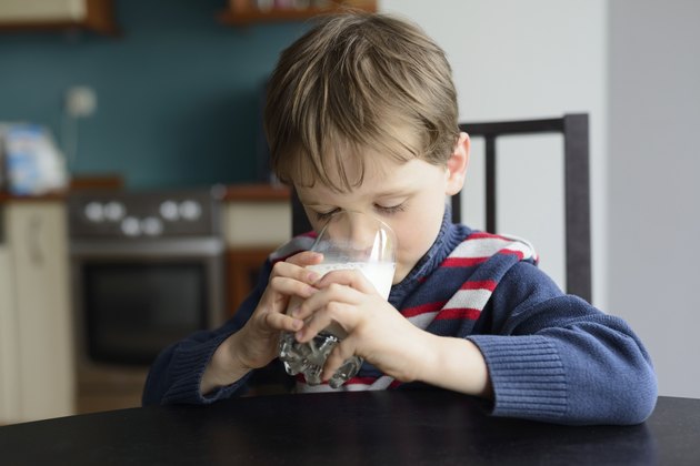 preschooler politely drinking milk at the table