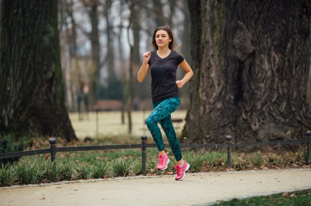 Young girl running outdoors in a city park