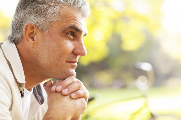 Middle-aged man sitting down and thinking, reflecting.