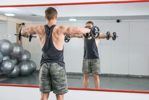 Man performing shoulders workout at the gym