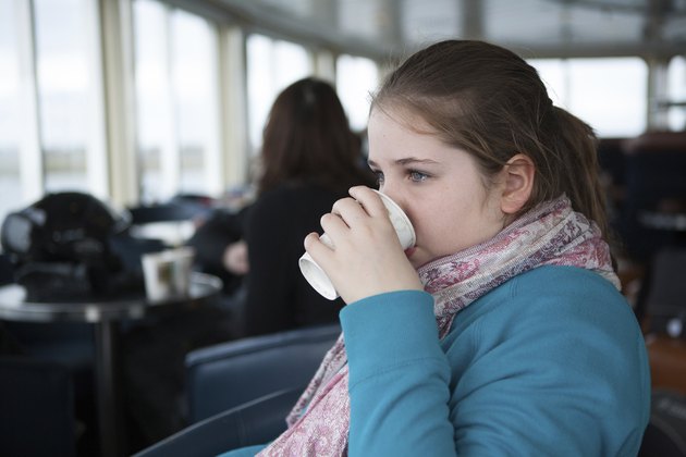 Young Teenage Girl Drinking From Paper Cup On a Ferry