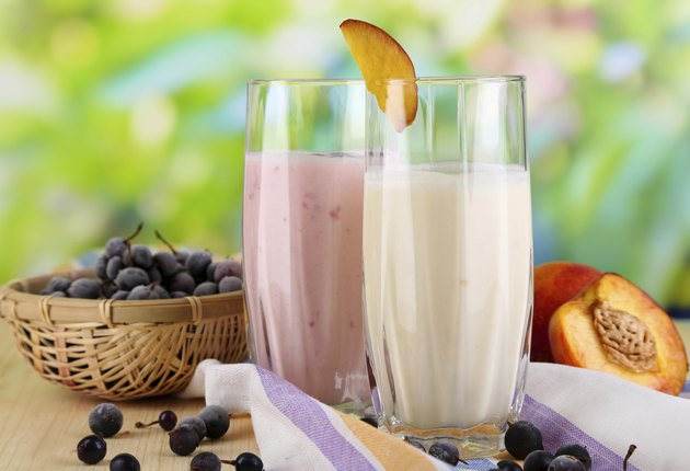 Delicious milk shakes with blackberry and peach on wooden table