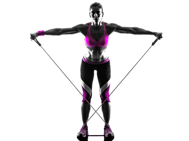 one caucasian woman exercising fitness resistance bands in studio silhouette isolated on white background