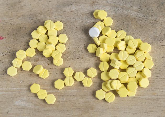 yellow pills on wooden background