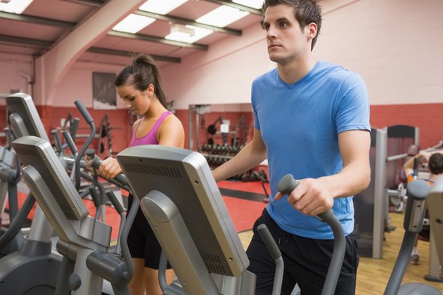 Woman and man stepping on step machines