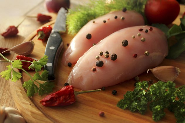 Raw chicken breasts on cutting board