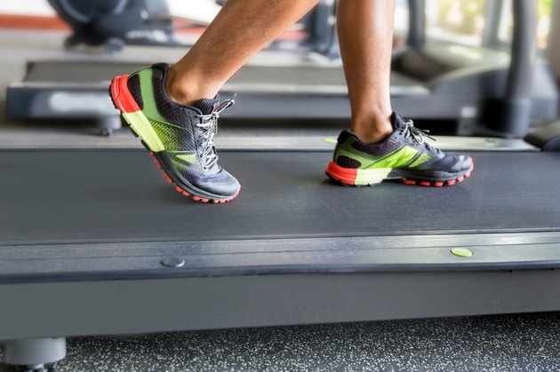 Close up man running on treadmill in the gym