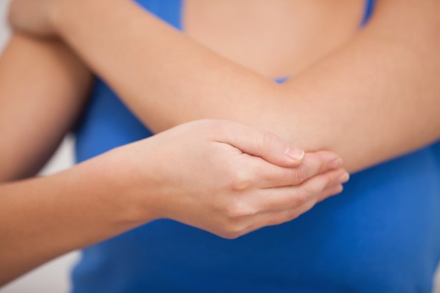 Woman holding her painful elbow