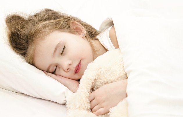 Adorable little girl sleeping in her bed