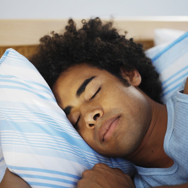 Close-up of mid adult man sleeping in bed
